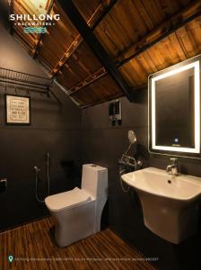 エルナクラムにあるShillong Backwatersの白いトイレと洗面台のあるバスルーム