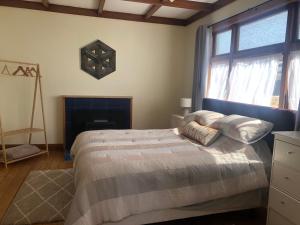 a bedroom with a bed and a fireplace and a window at Cambria Cottage in Nelson