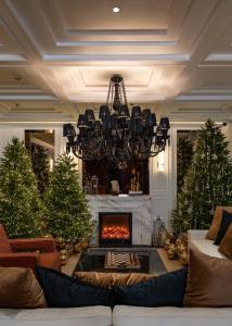 una sala de estar con chimenea y árboles de Navidad en The Savile, by Harry's, en Hanói