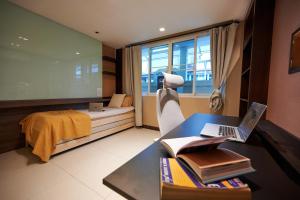 een slaapkamer met een bureau, een laptop en een bed bij office 2 in Bangkok
