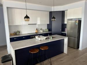 a kitchen with a counter with stools and a refrigerator at Pelicans Perch in Mannum