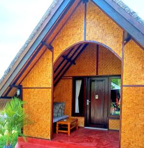 a small house with a large glass door at Kampung Meno Bungalows in Gili Meno