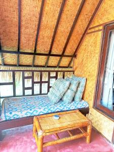 a bed in a room with a table and a bench at Kampung Meno Bungalows in Gili Meno +71 photos
