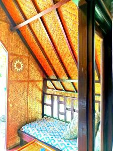 a bed in a room with a wooden roof at Kampung Meno Bungalows in Gili Meno +72 photos