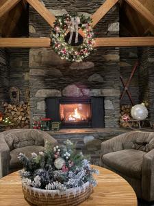 a living room with a fireplace with a christmas arrangement on a table at COZY LOON MOUNTAIN ESCAPE - Free shuttle, Pool, Hot tub, River&Mnt Views in Lincoln