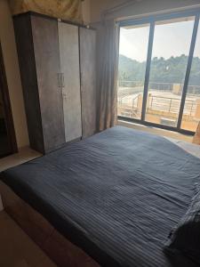 Sea view villa في Harnai: غرفة نوم بسرير كبير مع نافذة كبيرة +8 صور