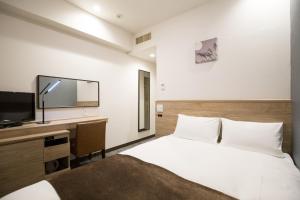 a bedroom with a bed and a flat screen tv at Nest Hotel Osaka Shinsaibashi in Osaka