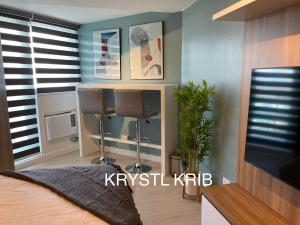 a bedroom with a desk and two chairs in a room at KRYSTL KRIB Azure North in San Fernando +33 photos