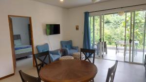 een woonkamer met een houten tafel en stoelen bij Villas Pura Vida - Mango in Puntarenas +25 foto's