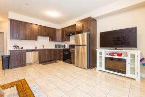 Beach Breeze White Rock في وايت روك: مطبخ كبير مع خزائن خشبية وأجهزة حديد قابلة للصدأ +9 صور