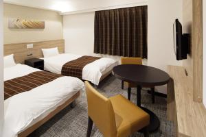 a hotel room with two beds and two tables at Nest Hotel Osaka Shinsaibashi in Osaka