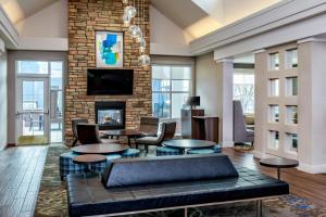 a living room with tables and a fireplace at Residence Inn by Marriott Denver Airport at Gateway Park in Aurora
