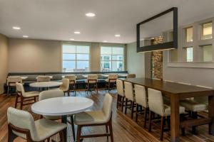 a dining room with tables and chairs and a mirror at Residence Inn by Marriott Denver Airport at Gateway Park in Aurora