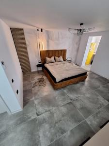 1 dormitorio con 1 cama y suelo de baldosa grande en Ssalamandra home's, en Ocna-Mureşului
