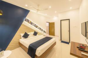 a bedroom with a king sized bed and a tv at Itsy By Treebo - Corner stay in Coimbatore