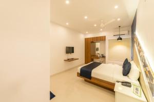 a hotel room with a bed and a tv at Itsy By Treebo - Corner stay in Coimbatore