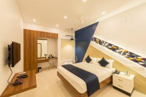 a bedroom with a bed and a tv in it at Itsy By Treebo - Corner stay in Coimbatore