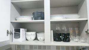 a white cabinet filled with bowls and dishes at 황리단길 대릉원 천마총 도보 5분 아늑한 퀸침대 투룸 3-1 in Gyeongju