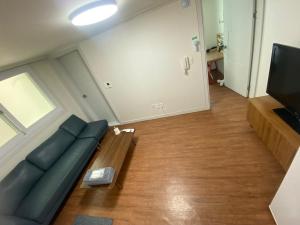 a living room with a couch and a television at 황리단길 대릉원 천마총 도보 5분 아늑한 퀸침대 투룸 3-1 in Gyeongju +7 photos