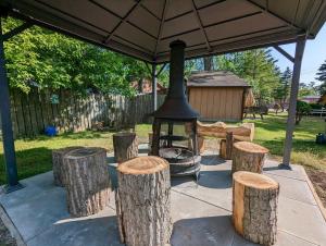 a group of logs and a grill under a tent at Tiny Wood Cottage 06 in Wasaga Beach