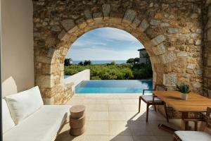 an external view of a villa with a swimming pool at The Westin Resort, Costa Navarino in Romanós