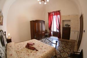1 dormitorio con cama y cortina roja en L'Angolo Antico, en Castellana Grotte