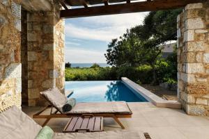 a villa with a swimming pool and a chair next to at The Westin Resort, Costa Navarino in Romanós