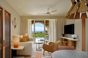 a living room with a couch and a tv at The Westin Resort, Costa Navarino in Romanós