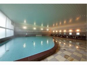 a large swimming pool in a large building at Harazuru Grand Sky Hotel in Asakura