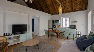 a living room with a couch and a table at 4131 Beach Drive Bliss & Flip Flop Cottage in Struisbaai