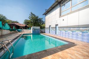 a swimming pool in front of a building at Balaji Excellency Resort in Mahabaleshwar