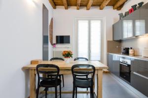 ミラノにあるMilano Porta Veneziaのキッチン(木製テーブル、黒い椅子付)