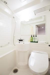 a white toilet sitting next to a white sink at Nest Hotel Osaka Shinsaibashi in Osaka