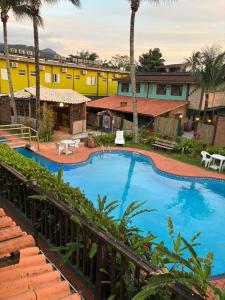 a view of a swimming pool at a resort at Lua Chalés 14 chalés equipados com churrasqueira, piscina e hidro incluindo café da manhã , roupa de cama, toalhas de banho e de praia a apenas 600 metros da praia de Maresias in Maresias