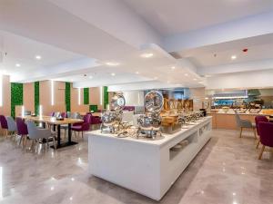 Una cocina y un comedor con mesa y sillas. en Lavande Hotel Foshan Shunde Daliang Qinghuiyuan Shihu Road, en Shunde