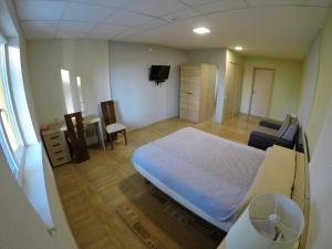 1 dormitorio con 1 cama grande y TV en Kambarių nuoma Kačerginės kurorte, en Kačerginė