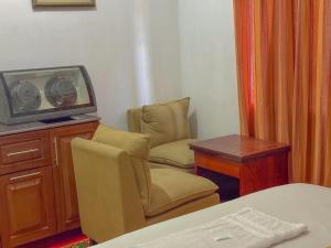 Sanhinda Rooms Nugegoda في نوغيغودا: غرفة بها تلفزيون وكرسي وطاولة +31 صورة