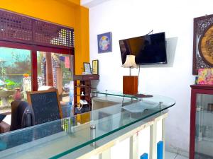 Sanhinda Rooms Nugegoda في نوغيغودا: طاولة زجاجية في غرفة بها تلفزيون