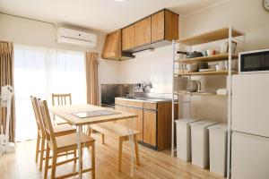 een keuken met een tafel en een koelkast bij 駅近商業施設近くで便利 静かで心ほぐれる滞在が叶う宿neuk Hill 定員5名 無料駐車場有 in Fukuroi