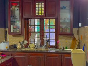 Sanhinda Rooms Nugegoda في نوغيغودا: مطبخ مع حوض وبعض النوافذ الزجاجية الملونة