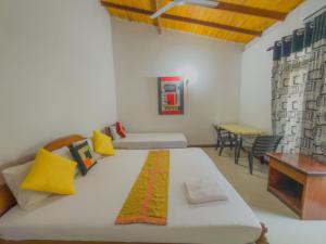 Sanhinda Rooms Nugegoda في نوغيغودا: غرفة نوم بها سرير كبير وطاولة