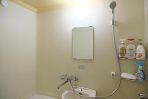een badkamer met een wastafel en een spiegel bij 駅近商業施設近くで便利 静かで心ほぐれる滞在が叶う宿neuk Hill 定員5名 無料駐車場有 in Fukuroi