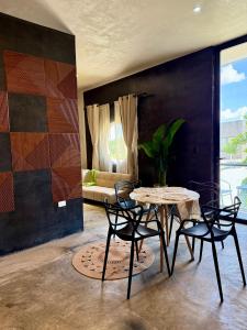 Un comedor con una mesa y sillas y un sofá. en Departamento Belembi merida, en Mérida