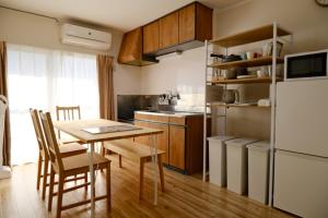een keuken met een tafel en een koelkast bij 駅近商業施設近くで便利 静かで心ほぐれる滞在が叶う宿neuk Hill 定員5名 無料駐車場有 in Fukuroi +16 foto's