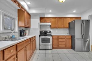 Una cocina con gabinetes de madera y un refrigerador de acero inoxidable. en Bright 3BR Upper Level Stay • Pet Friendly, en Windsor
