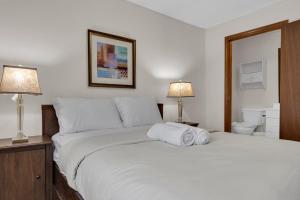 Un dormitorio con una gran cama blanca con dos lámparas. en Bright 3BR Upper Level Stay • Pet Friendly, en Windsor