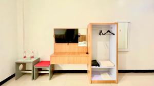 a small room with a tv and a shelf at Berlian Guest House Syari'ah in Martapura