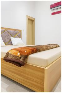 a bed with a wooden platform with a blanket on it at Surya Nagar Hotel M - Residency Near Baba Ji Gurudev Mandir- Sri Krishna Janmabhoomi - Room Service and Parking facilities - Fully Air conditioning Luxuary Room - Top Rated Hotel In Mathura in Mathura
