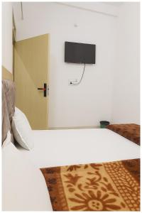 a bedroom with a bed with a tv on the wall at Surya Nagar Hotel M - Residency Near Baba Ji Gurudev Mandir- Sri Krishna Janmabhoomi - Room Service and Parking facilities - Fully Air conditioning Luxuary Room - Top Rated Hotel In Mathura in Mathura