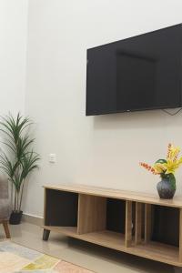 a living room with a television on a wall at Abu Rakan Apartment in Muscat +76 photos